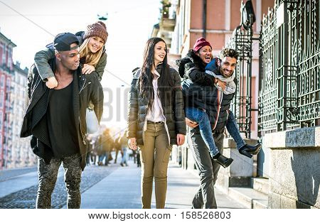Group of multi-ethnic friends walking on the streets and smiling - Young people having fun outdoors