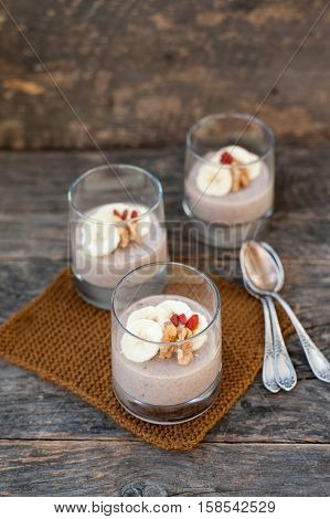 View of chocolate pana cota with banana and goji berry on a wooden table