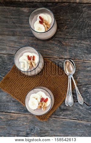 View of chocolate pana cota with banana and goji berry on a wooden table