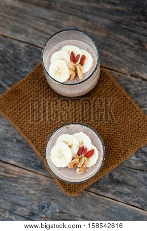 View of chocolate pana cota with banana and goji berry on a wooden table