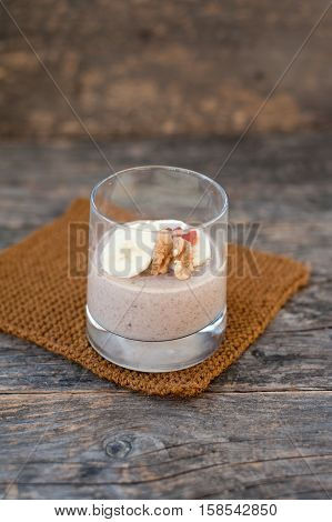 View of chocolate pana cota with banana and goji berry on a wooden table