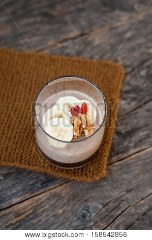 View of chocolate pana cota with banana and goji berry on a wooden table