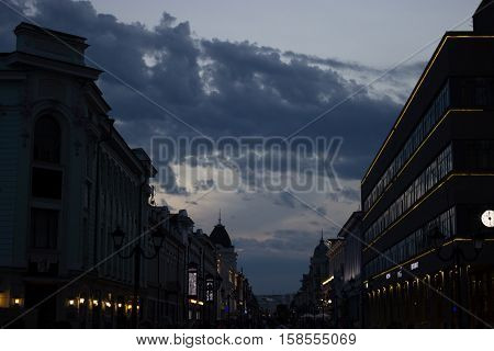 dark street buildings silhouette and drammatic cloudy sky