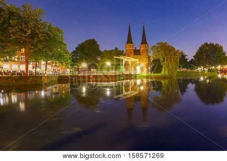 Eastern Gate, Oostpoort, with the white draw bridge, along Delftse Schie canal at night, Delft, Holland, Netherlands
