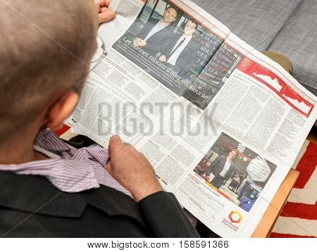 PARIS FRANCE - NOV 12 2016: Man reading Le Figaro French Entrepreneur newspaper - cover with showroomprive.com first day on stock market