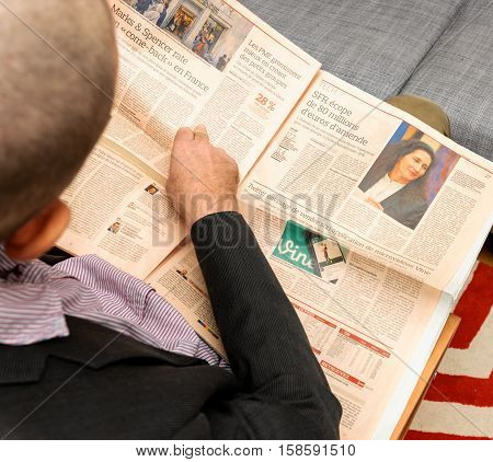 PARIS FRANCE - NOV 12 2016: Man reading Le Figaro French Economie newspaper - Marks and Spencer problems in France