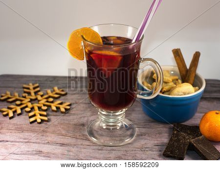 glass mug of mulled wine with spices and biscuits on the table