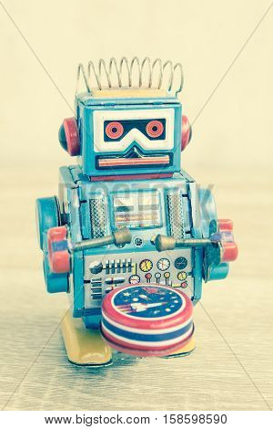 Old robot toy on wood table, vintage color style, vintage tone background.