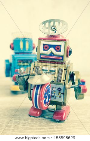 Old robot toy on wood table, vintage color style, vintage tone background.