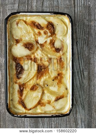 close up of rustic golden scalloped potato gratin dauphinois