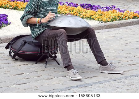 the man on the street plays a percussion instrument hang