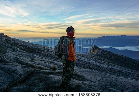 Ranau,Sabah-March 13,2016:Silhouette of man enjoying the amazing view on the summit of Kinabalu Mountain before moving down to Laban Rata after successfully conquering the Mountain Kinabalu,Sabah.