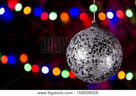 hanging new year ball on a christmas garland background