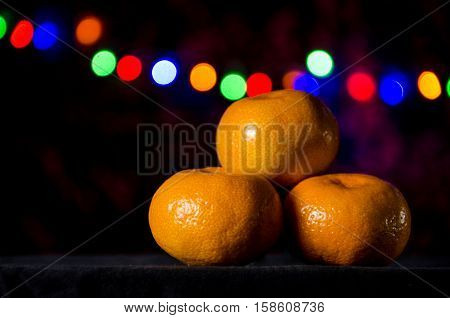 Christmas tangerine or mandarin on a Christmas garland background