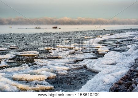A winter landscape in the sunset with packed ice in the sea.