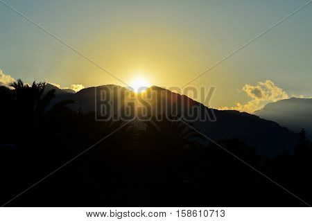 the beautiful sun sets behind the mountain