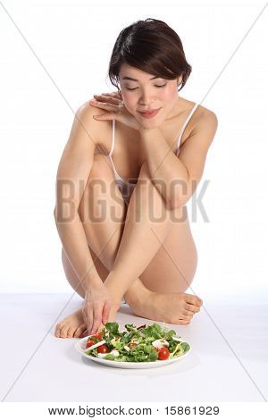 Smuk pige med salat måltid