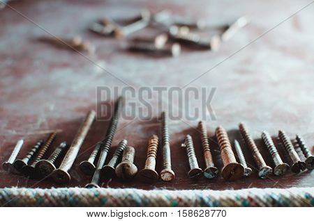 On the old table are the screws in different sizes and nails texture background
