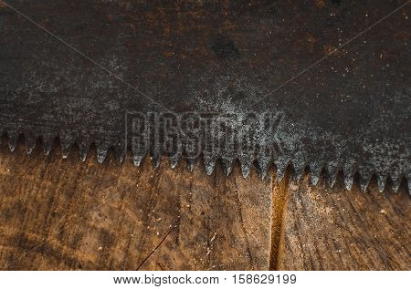 a hacksaw on the old table background texture lies