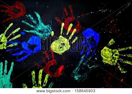 hand prints in rainbow on black background