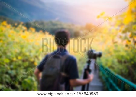 Blurred image Photographer holding dslr camera and watching the sunset