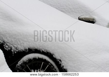 Close up of a car covered with snow after snowfall in winter. Copy space for text.
