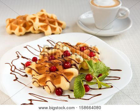 Dessert waffles with cranberries and chocolate syrup