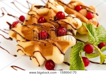 Dessert waffles with cranberries and chocolate syrup