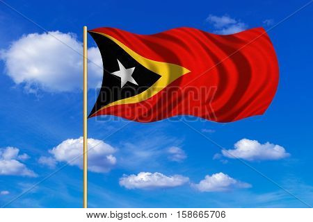 East Timorese national official flag. Patriotic symbol banner element background. Correct colors. Flag of East Timor on flagpole waving in the wind blue sky background. Fabric texture. 3D rendered illustration