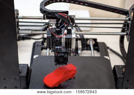 printer and printed models red machine is on the table