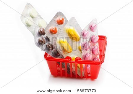 Colorful pills in shopping cart. Shopping trolley with pills and medicine isolated on white.