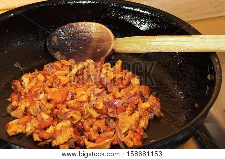 cooking chanterelle in black pan( Cantharellus cibarius )