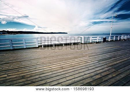White bench on wooden pier in Sopot Poland. Jetty on the water. Baltyk sea.