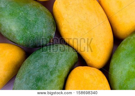 a pile yellow ripe mango and fresh green mango  on white background healthy fruit food isolated