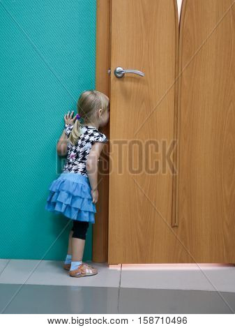 The girl looked in through the door. Girl peeping as are classes in school. The girl was late to class.