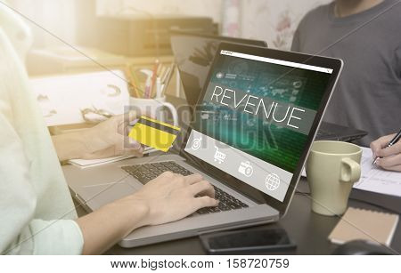 business hand typing on computer keyboard with credit card and Revenue homepage on the computer screen business freelance concept.