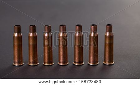 Empty rifle copper cartridges against black cardboard as a background. Macro.