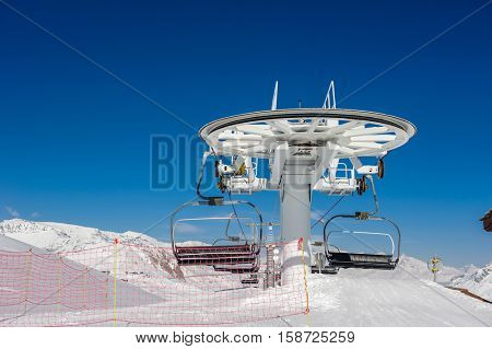 Ski lift station in mountains at winter. Alpine winter mountain landscape. French Alps covered with snow in sunny day. Val-d'Isere, Alps, France