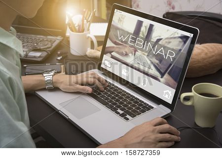 business hand typing on a laptop keyboard with Webinar homepage on the computer screen learning internet website web page concept.