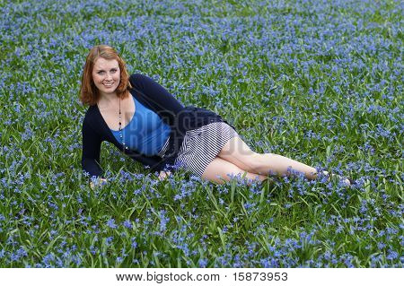 glad ung kvinde midt i blomster