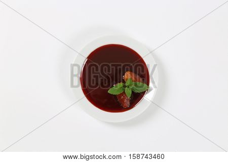 plate of date syrup with dates on white background