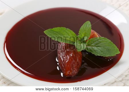 plate of date syrup with dates - close up
