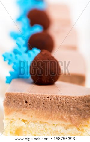 Delicious mousse cakes with chocolate truffles and blue mastic snowflakes. Macro. Photo can be used as a whole background.