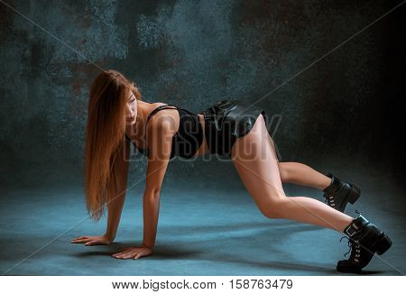 Attractive girl dancing twerk iat the blue studio background