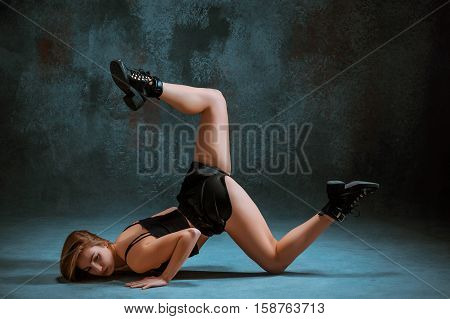Attractive girl dancing twerk iat the blue studio background