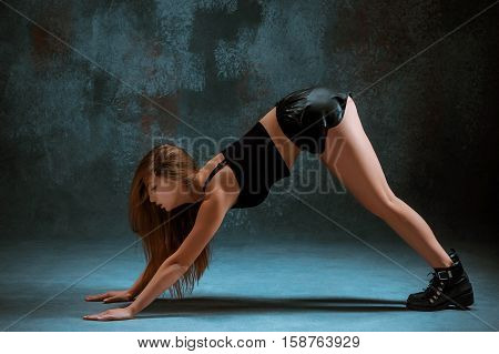 Attractive girl dancing twerk iat the blue studio background