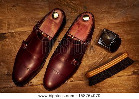 Still life with men's leather shoes and accessories for shoes care.