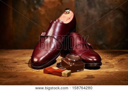 Still life with men's leather shoes and accessories for shoes care.