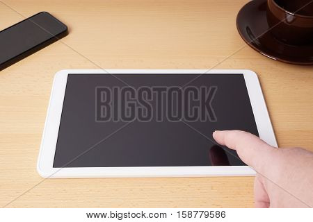 finger touching blank touchscreen of tablet computer from personal perspective or point of view