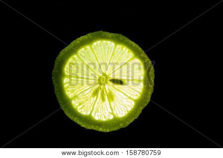 Slice of ripe Lime isolated on a dark background